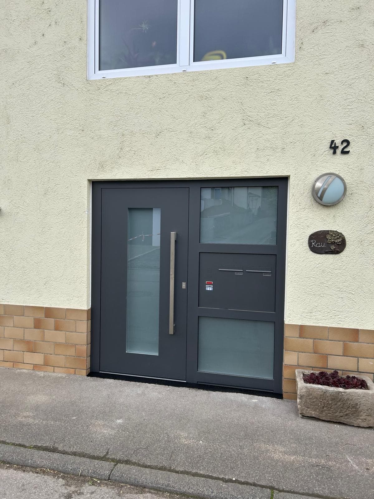 Moderne Aluminium-Haustüre mit Seitenteil, Briefkasten und Klingelanlage